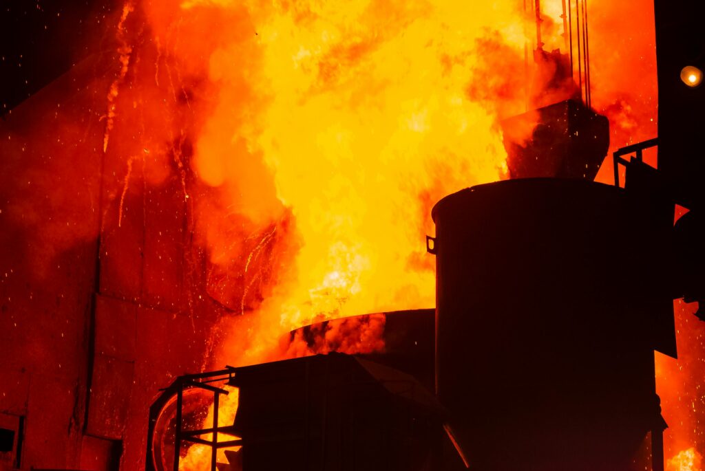 A powerful image of an industrial furnace with intense flames and sparks creating a dramatic scene.
