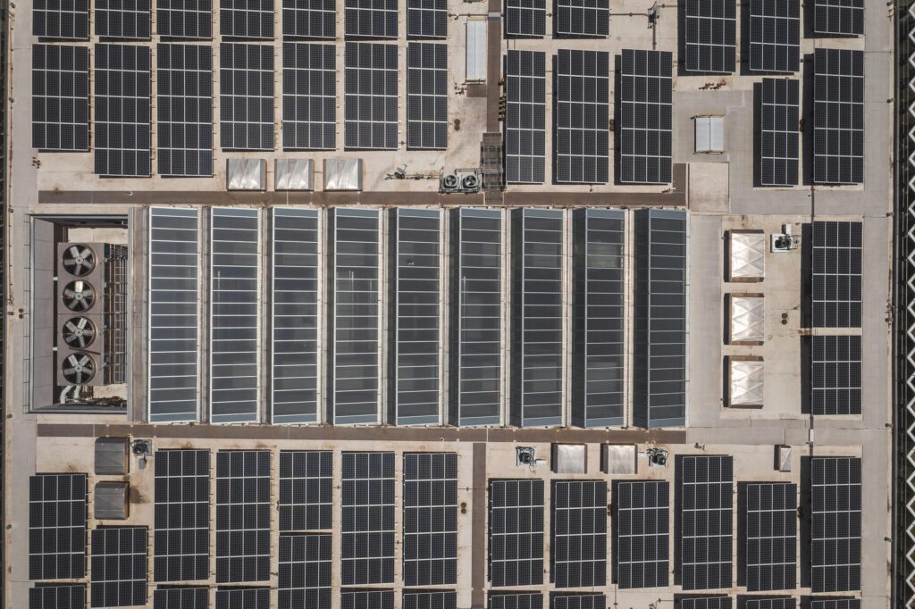 High-angle drone shot of rooftop solar panels showcasing renewable energy technology.